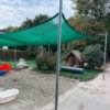 Sandkasten mit Sonnensegel und Spielhaus im Garten