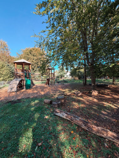 Garten mit Spielplatz und Bäumen, die Schatten spenden