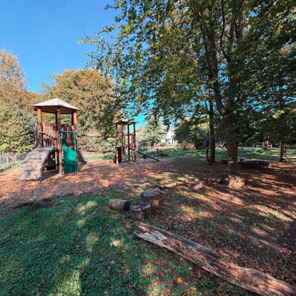 Garten mit Spielplatz und Bäumen, die Schatten spenden